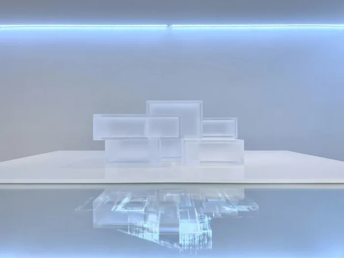Doorschijnend architectonisch schaalmodel van modern gebouw op wit oppervlak met zachte reflectie en blauwe verlichting